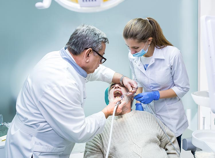 dentist performing teeth cleaning to patient