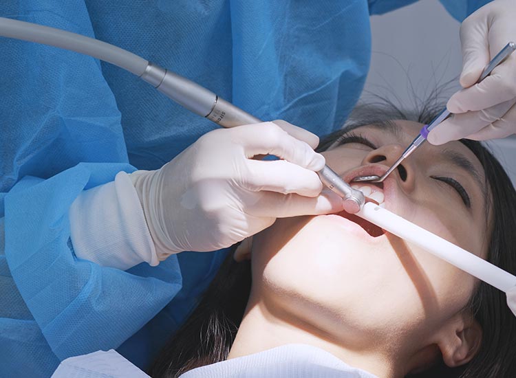 dentist performing deep cleaning on patient
