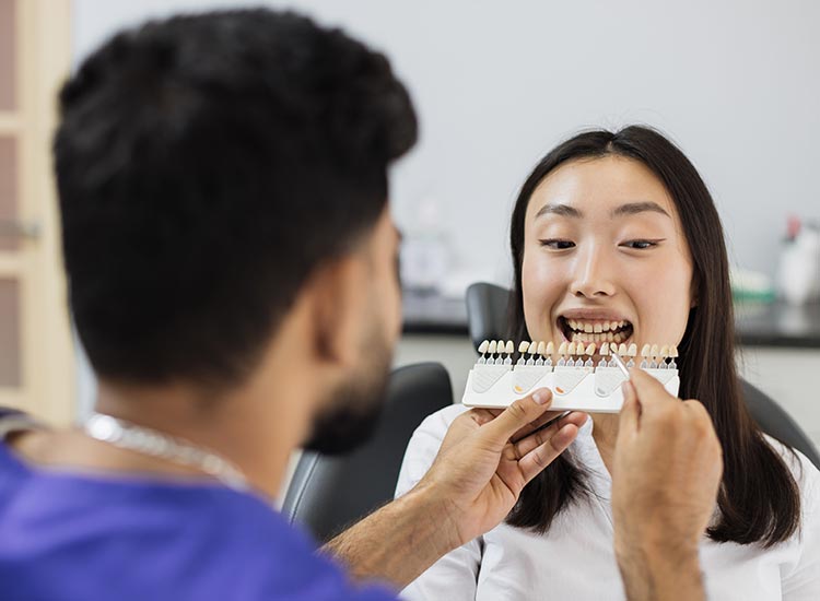 dentist choosing color of veneer for patient