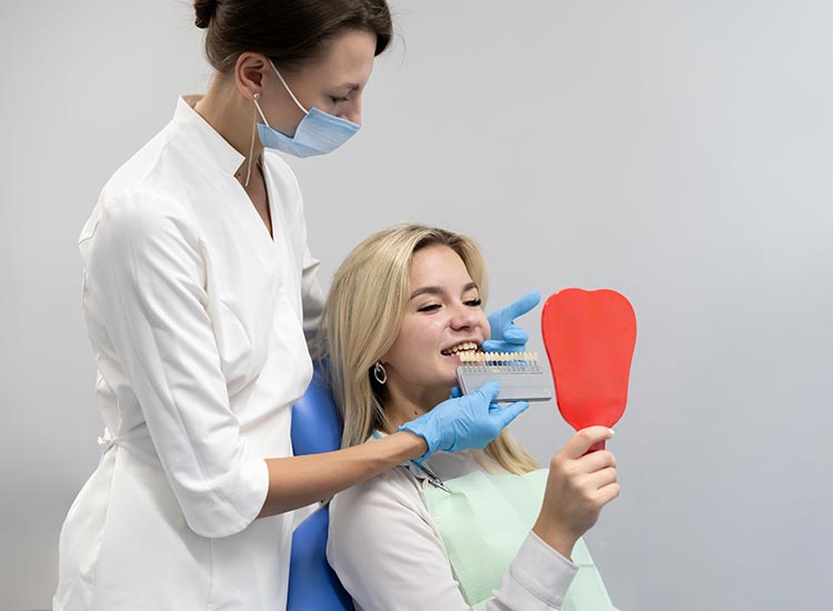 dentist helps choose teeth color for veneers