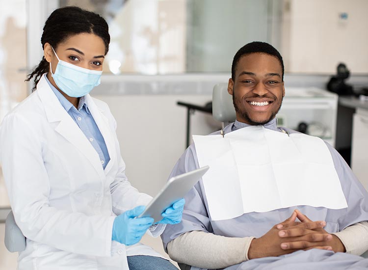 dentist and patient smiling at camera