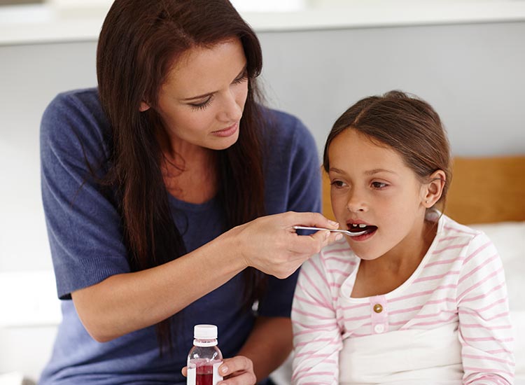 parent feeding child medicine