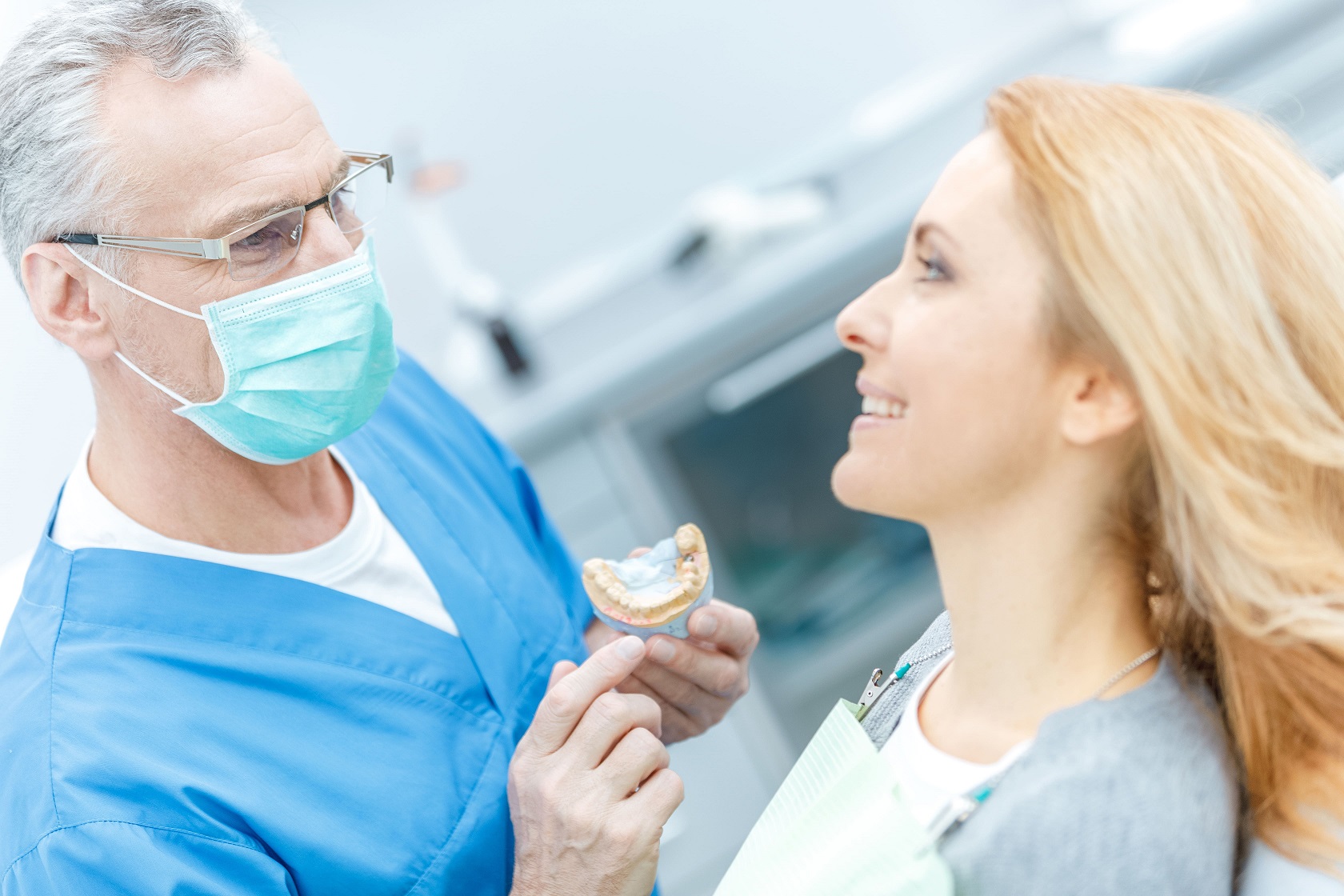 dentist showing tooth model to patient