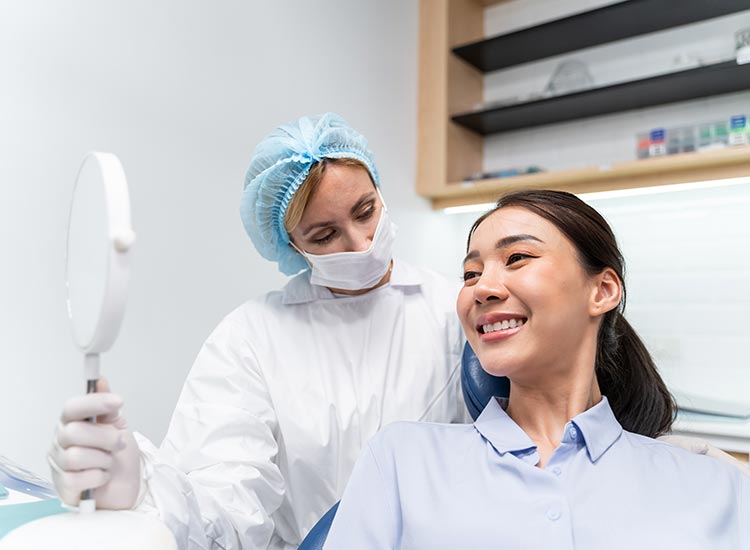 patient smiling with mirror in hand