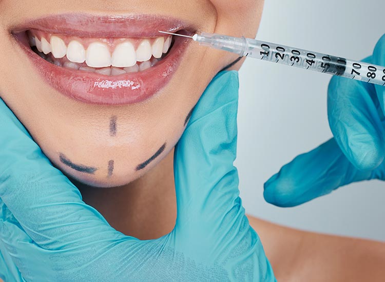 Cosmetic dentist performing lip injection treatment for smile enhancement
