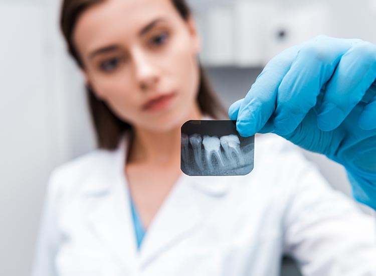 dentist examining tooth x-ray