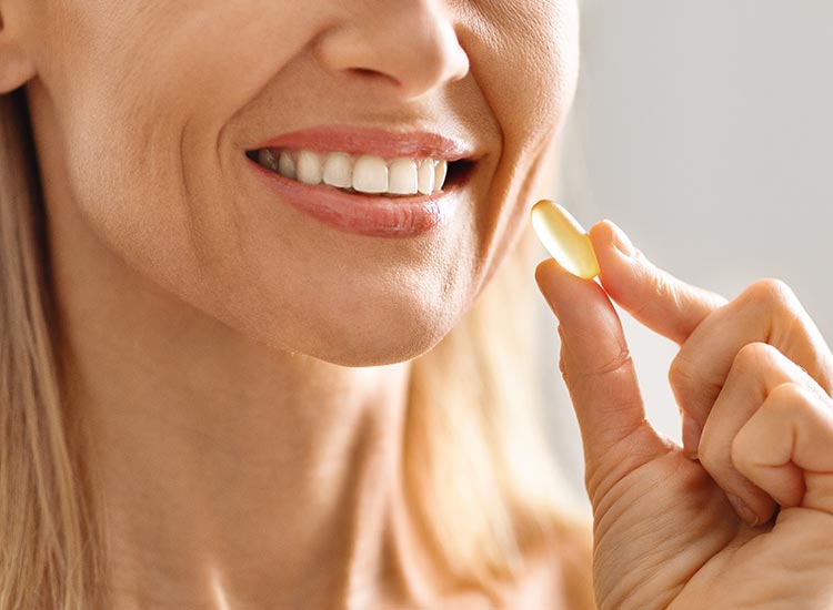 person smiling with vitamin in hand
