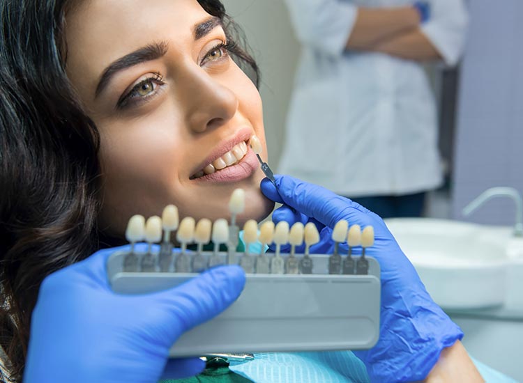 dentist finding right color for veneers for patient