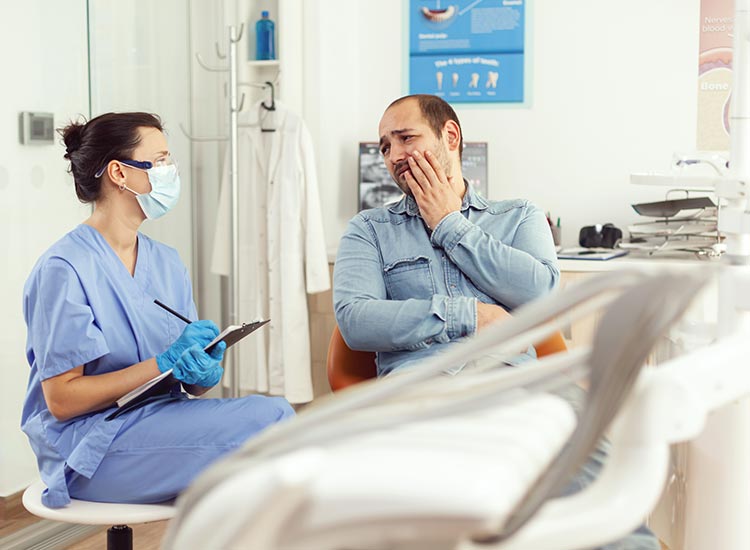 dentist listening to patient describing tooth pain