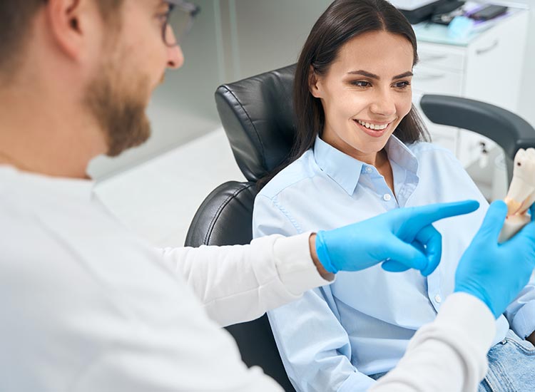 dentist showing patient a tooth model